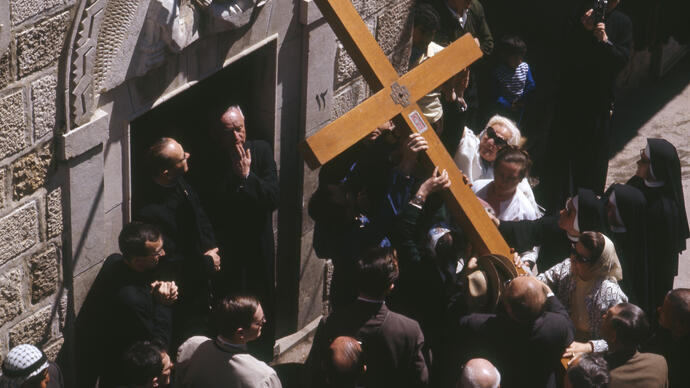 Photo of large cross being carried during performance of St John Passion