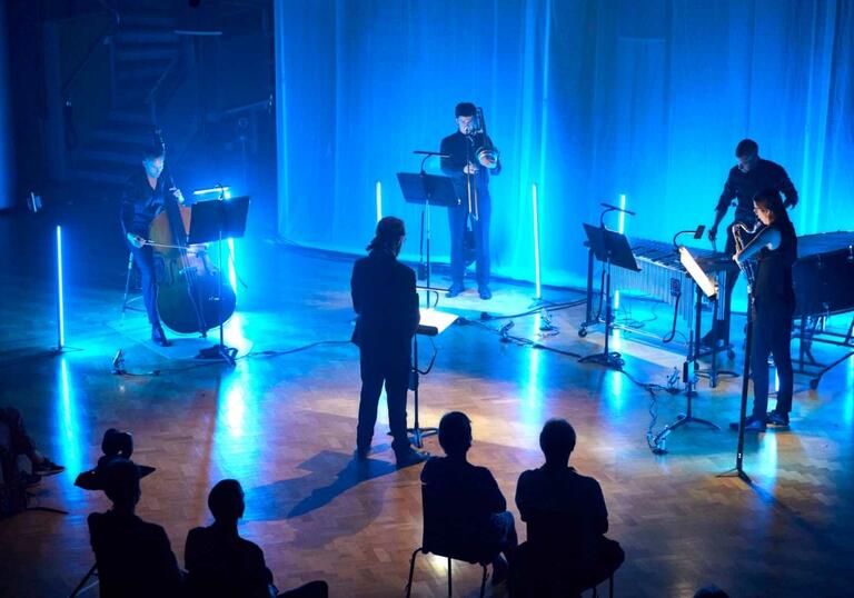 Musicians in a blue lit hall