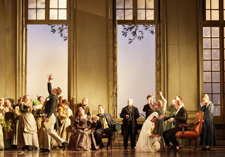 A court stand in a fanciful ballroom, all in period ball gowns and suits.
