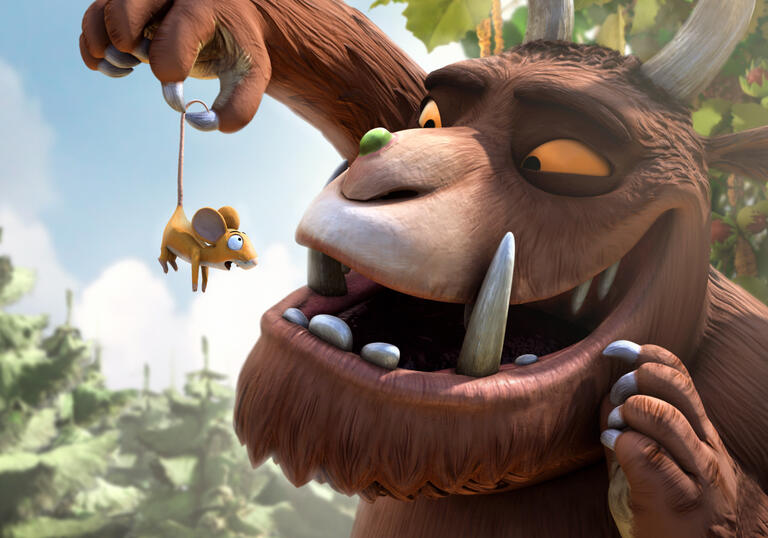 The Gruffalo holds a mouse by by his tail.