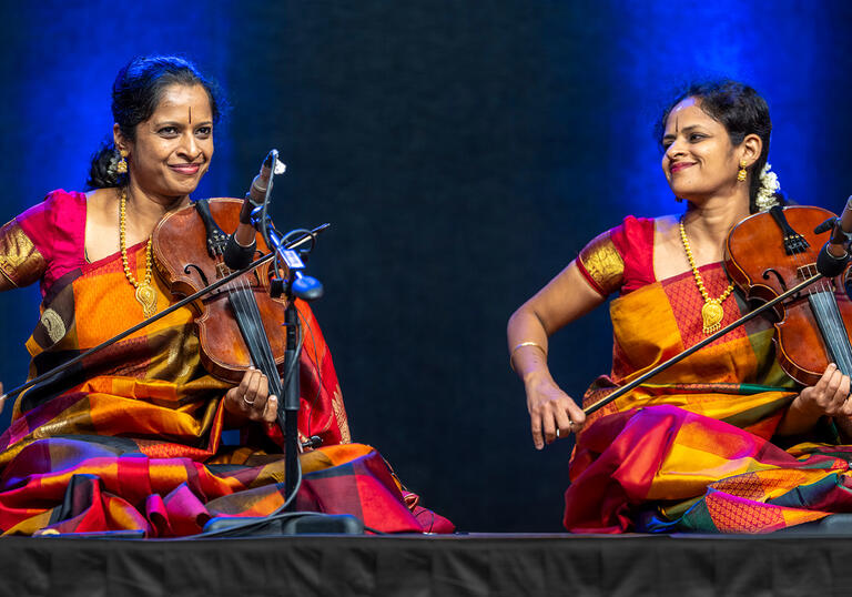 Akkarai sisters playing the violin on stage