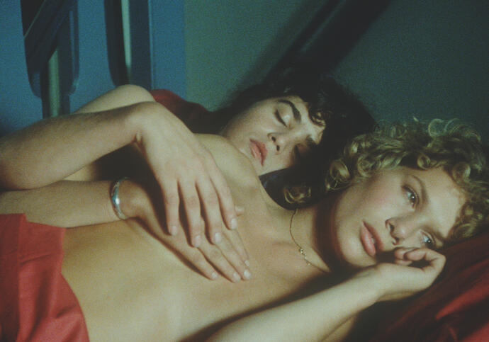 Two women lie in bed together in the morning. 