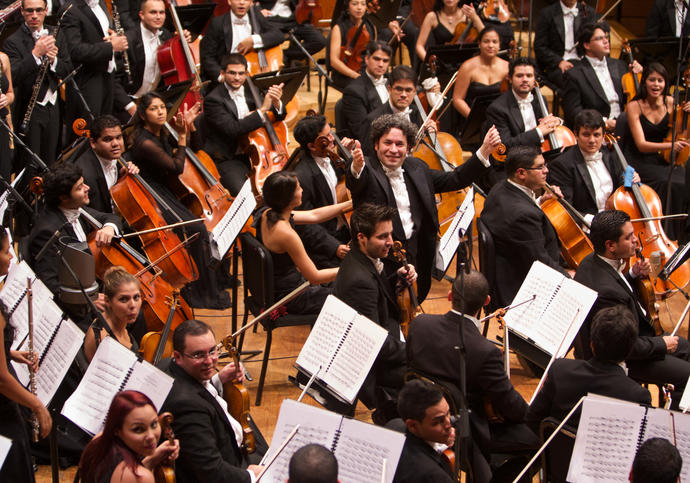 A full colour photograph of Gustavo Dudamel and the Los Angeles Philharmonic