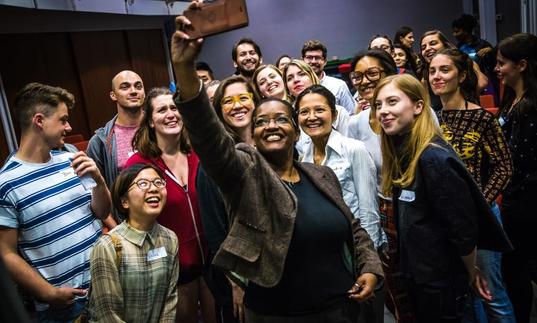 Photo woman taking selfie of group of young people