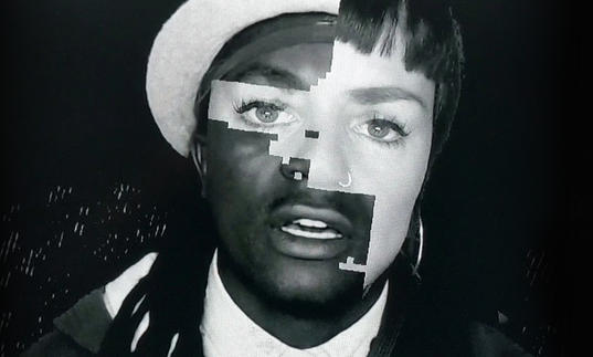 A black and white photograph of a black man and a white woman are pieced together in a digital glitch