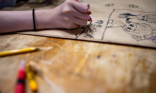 Child drawing on table in the Barbican Centre