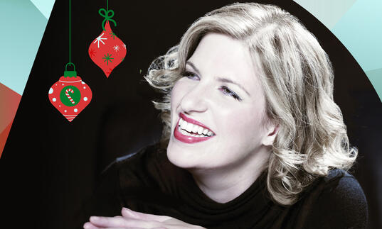 Clare Teal smiling, with turquoise and orange shapes bordering the image and two Christmas baubles hanging from the top of the image