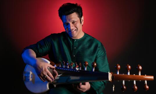 Amaan Ali Bangash holding a sarod