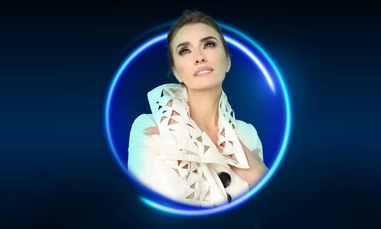 An image of Ermonela Jaho posing surrounded by a blue circle against a blue background
