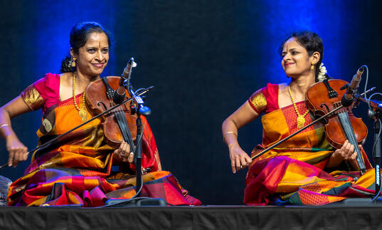 Akkarai sisters playing the violin on stage